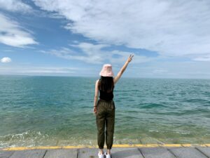 a woman in a pink hat is standing on a dock