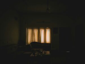 A dark room with a bed and a window